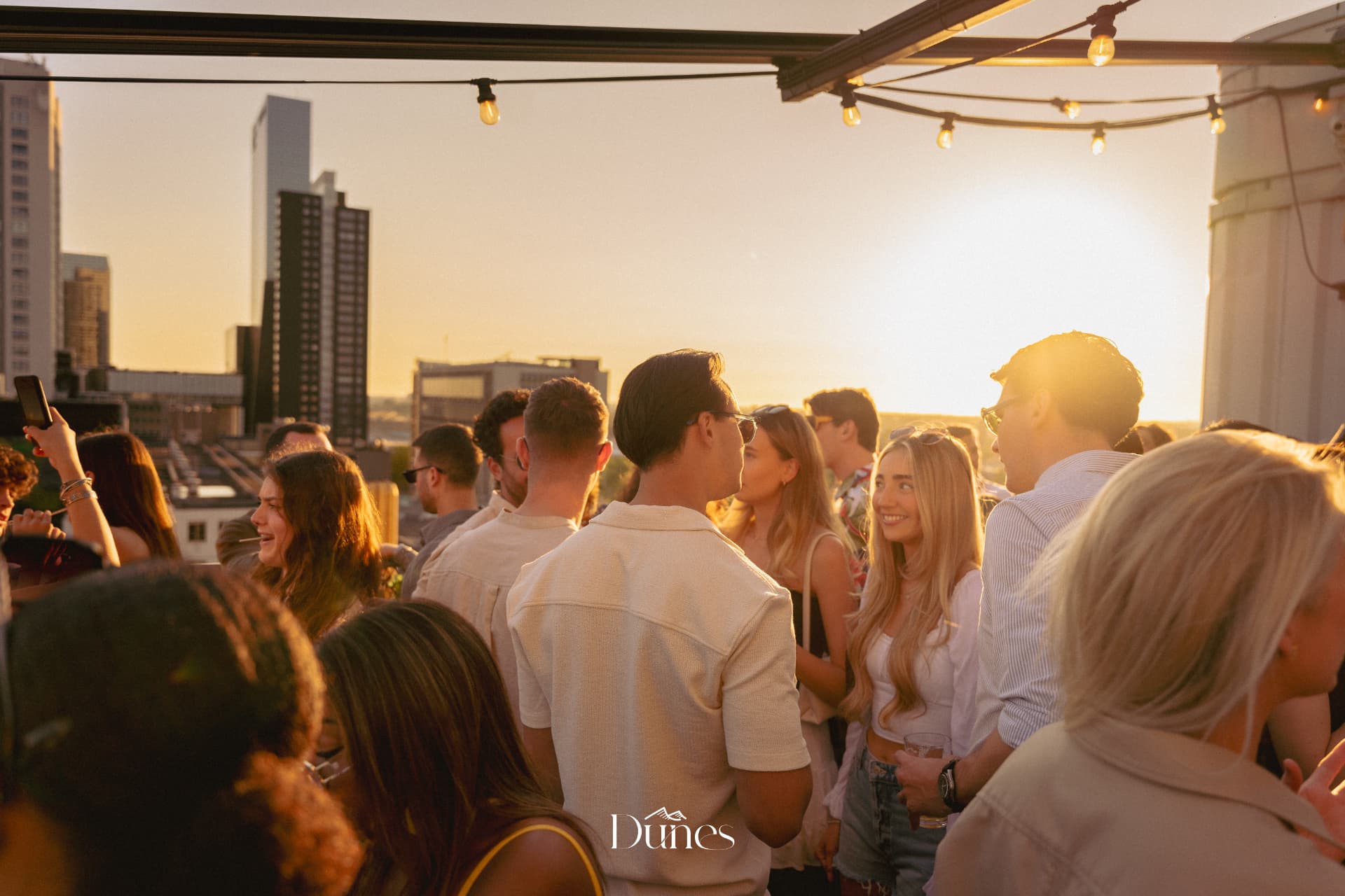 Rooftop crowd at sunset during a Dunes event